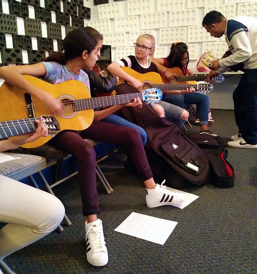 Young students sitting together for guitar lessons in San Benito County