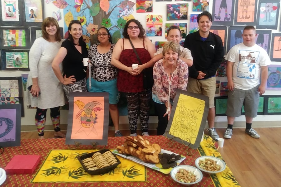 Group of Life Skills students pose for photograph next to art gallery on wall in San Benito County