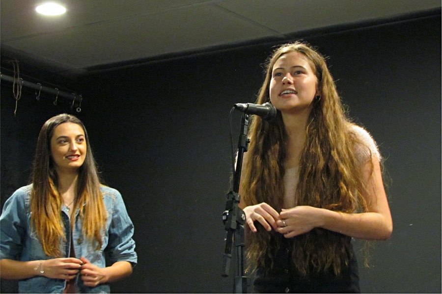 Arts education poetry outloud Young woman performing poetry outloud on stage